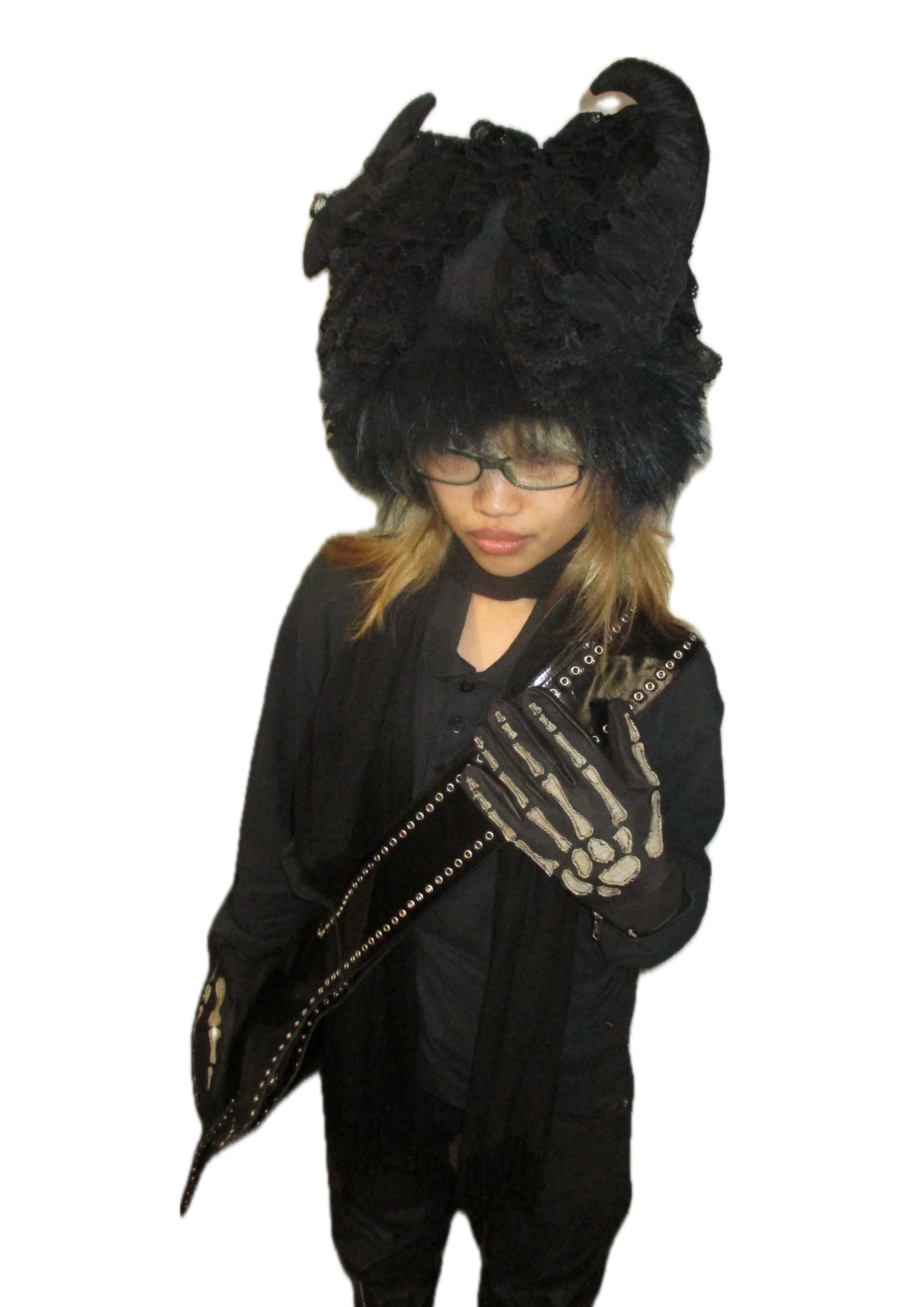 A person dressed in an all-black gothic-inspired outfit poses against a plain white background.