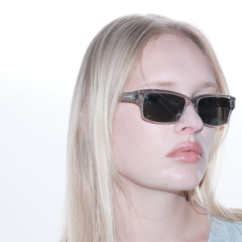 Person wearing sunglasses with a plain background