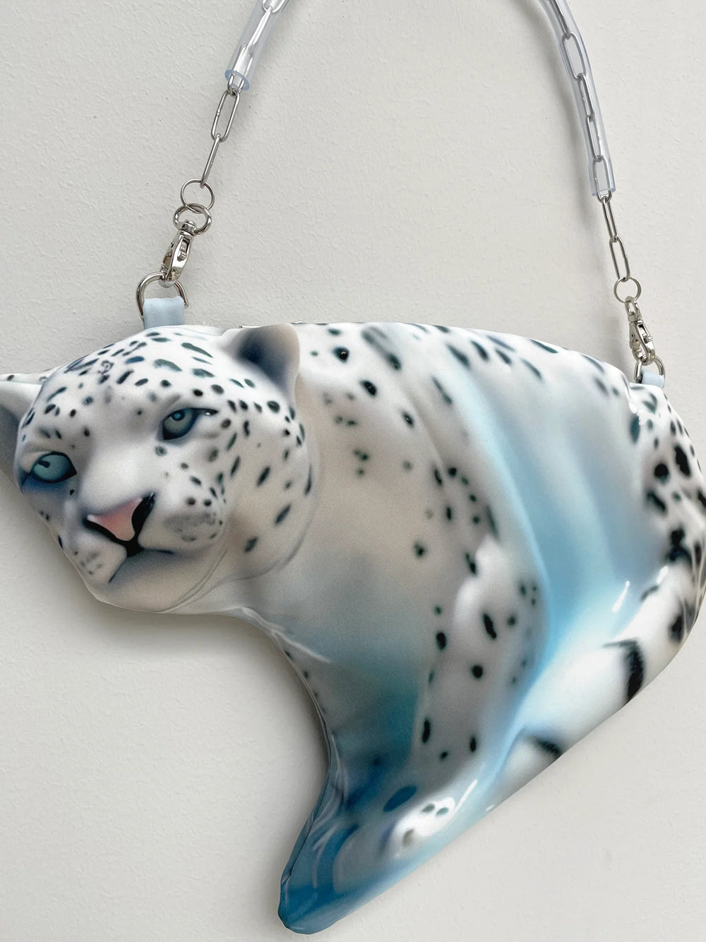 Glass sculpture of a snow leopard on a white background