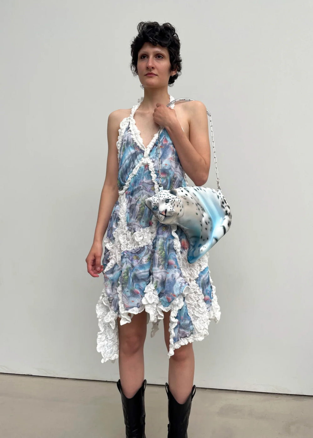 Woman wearing a floral dress with white lace details against a plain background
