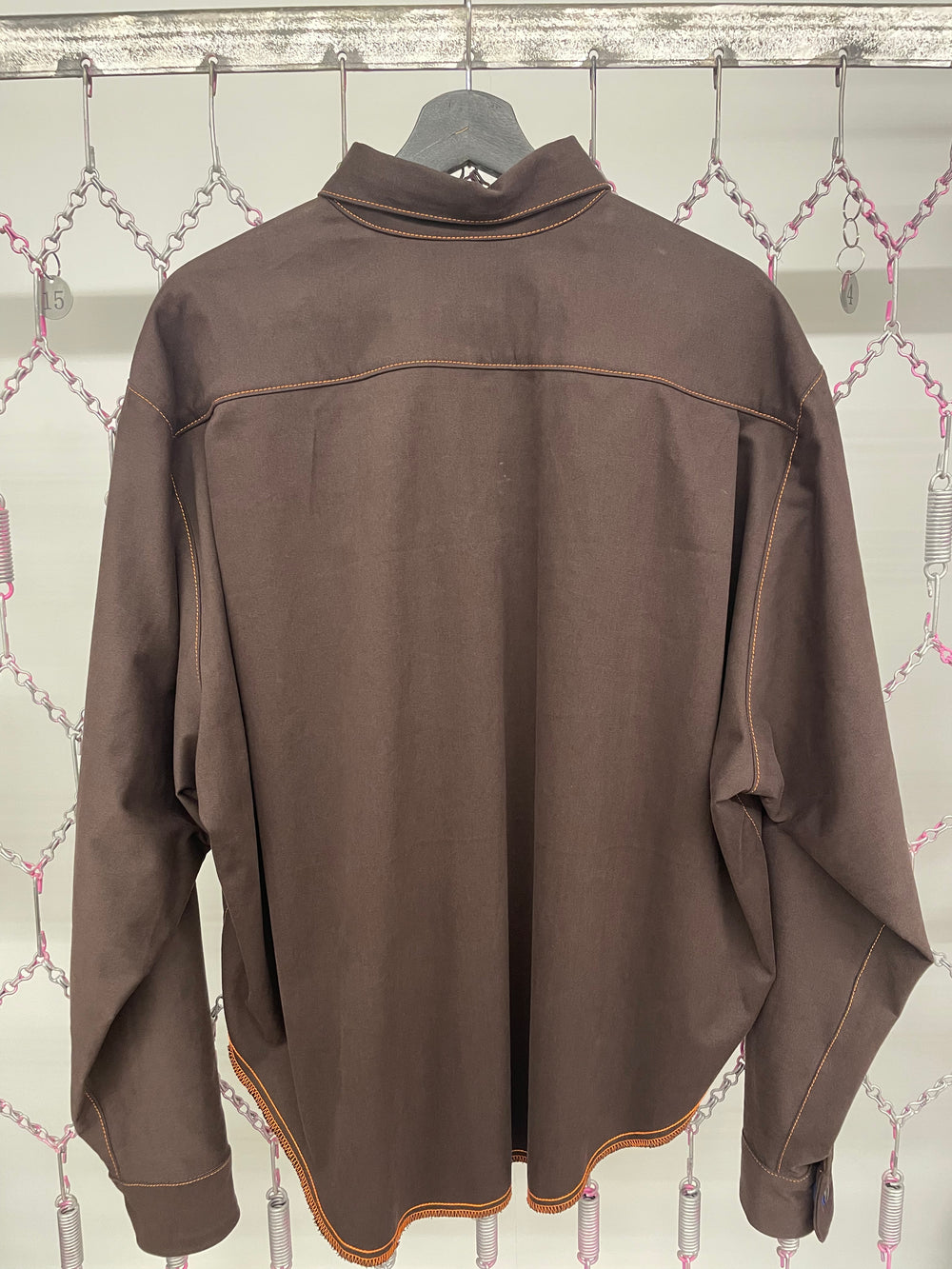 Brown jacket on a mannequin against a patterned wall