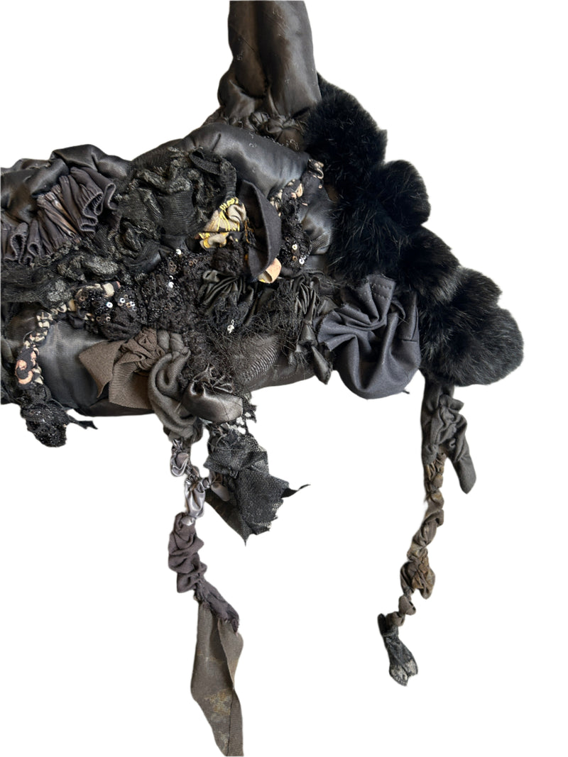 Black lace handbag with decorative elements on a wooden surface