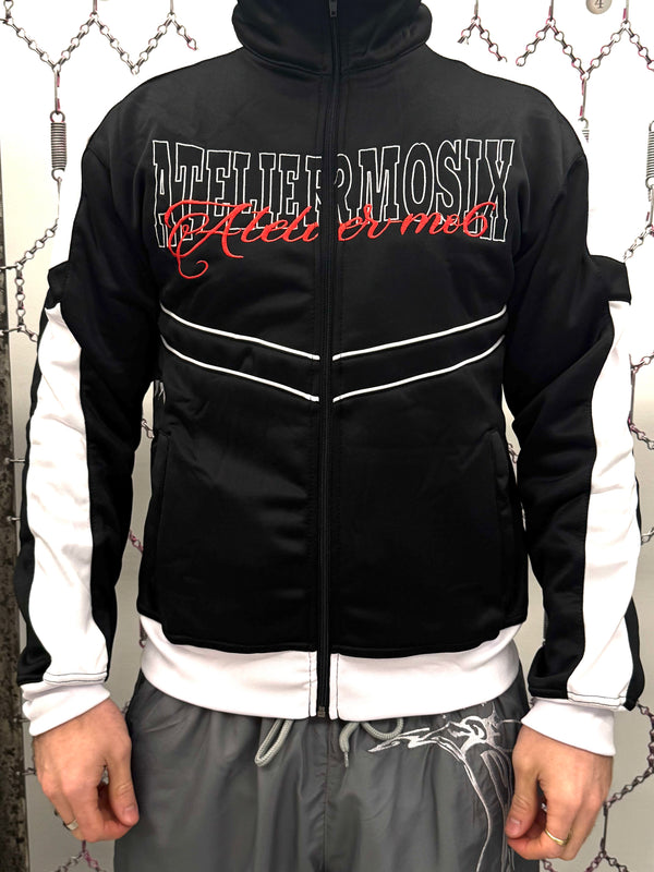 Zwarte streetwear track jacket met high-neck ritssluiting, contrast zijpanelen en grafische frontprint, premium midweight stof met geborduurde sterdetails en ribboorden, urban fashion Nederland.
