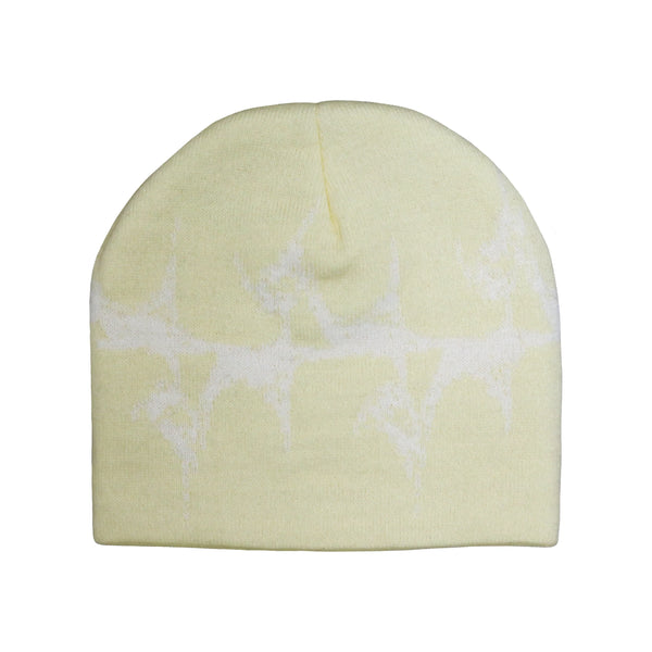 A pale yellow knit beanie featuring a subtle white abstract graphic design resembling a textured, organic pattern across the surface. The beanie has a simple, rounded shape with no visible logos or additional details.