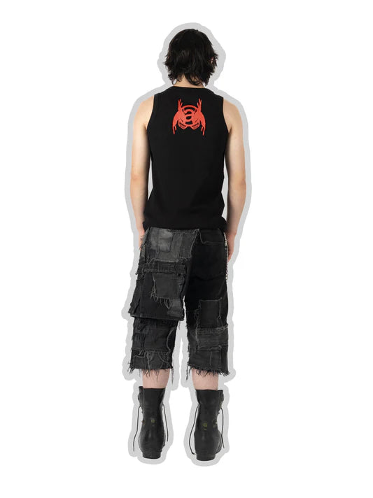 Person wearing a black sleeveless shirt with a red logo and black cargo shorts on a white background