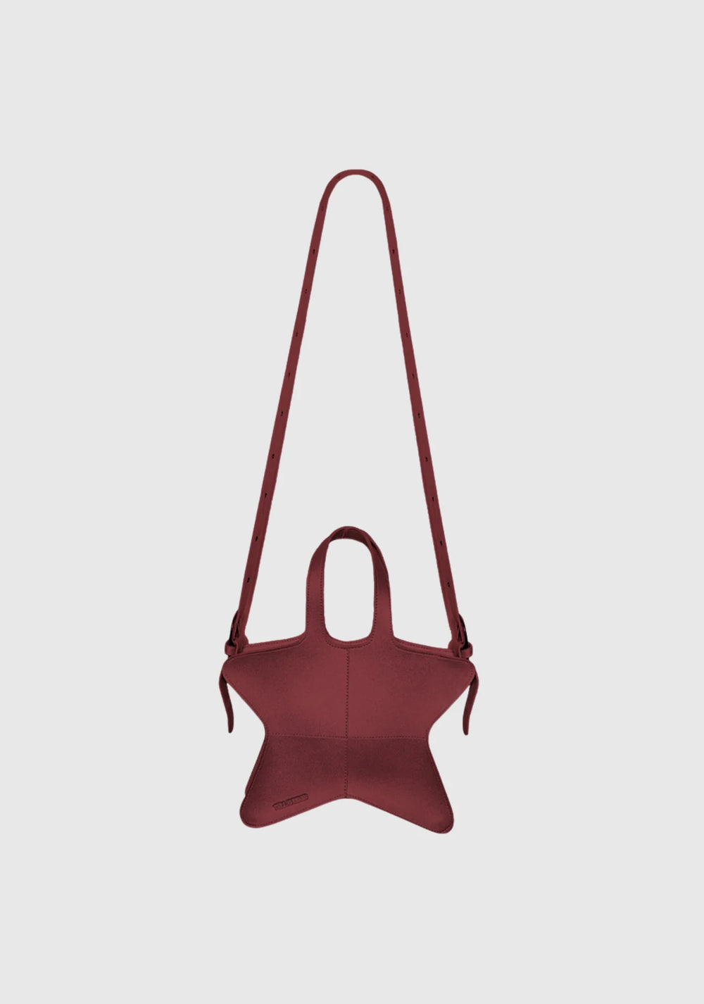 Wine red star-shaped shoulder bag with adjustable long strap and structured leather finish displayed on light grey background.