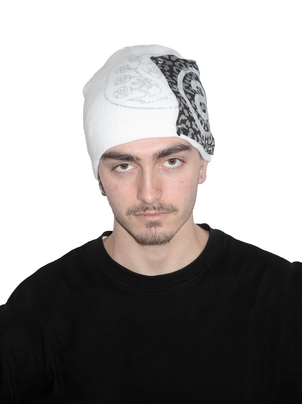 Man wearing a white beanie with a black and white pattern on a white background