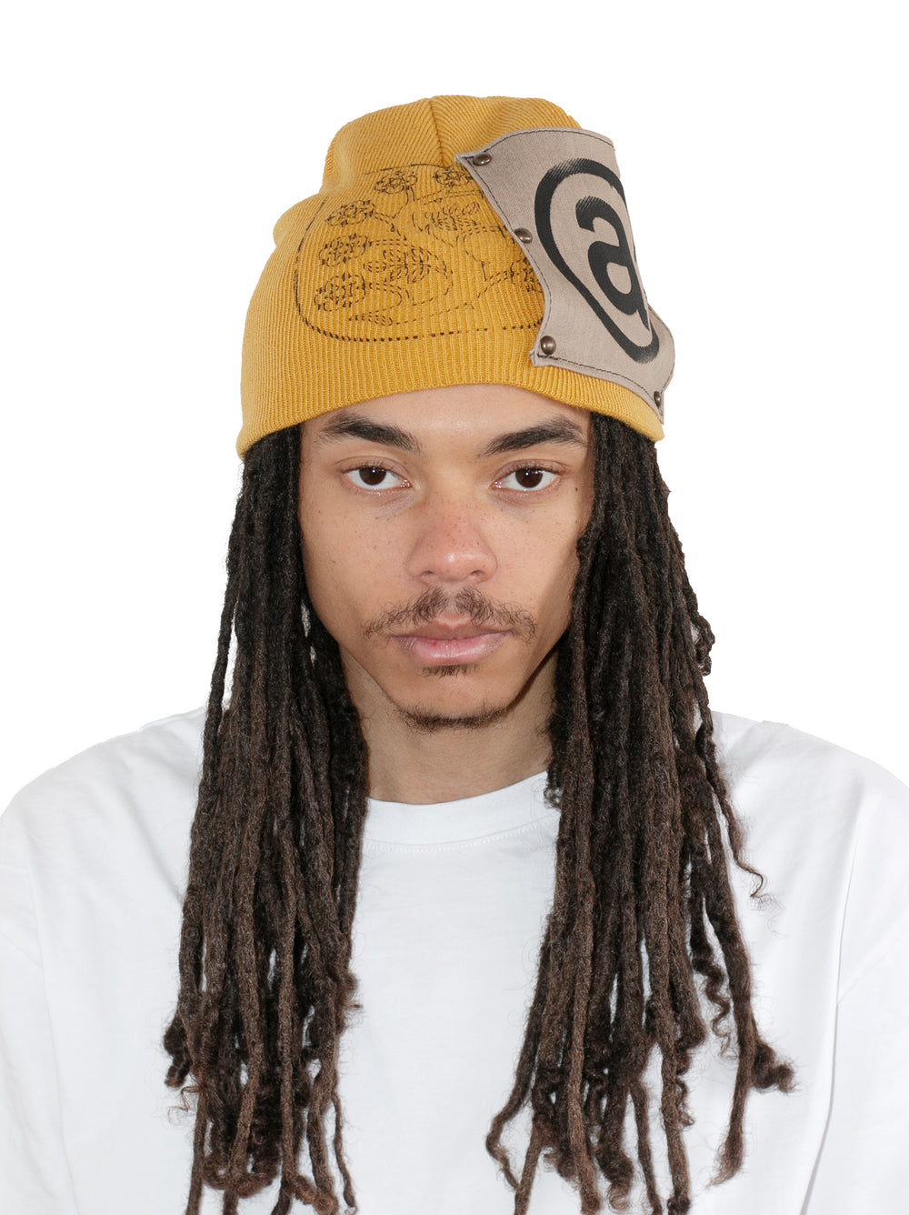 Person wearing a yellow and beige beanie with a logo on a white background