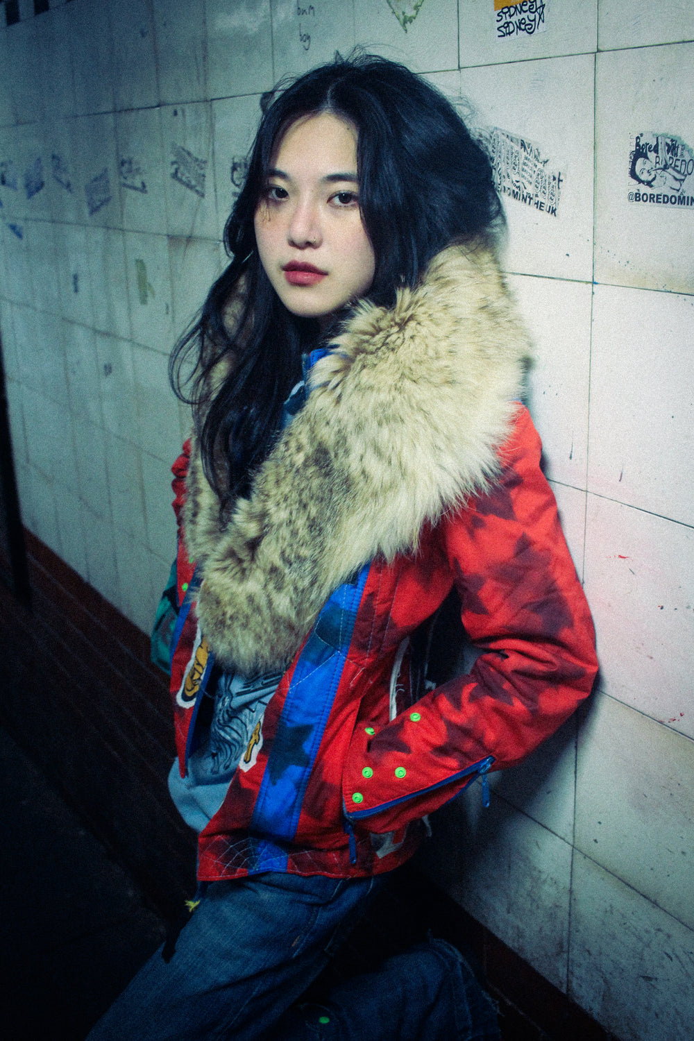 Fur hood styled as scarf over colorful jacket, worn look.