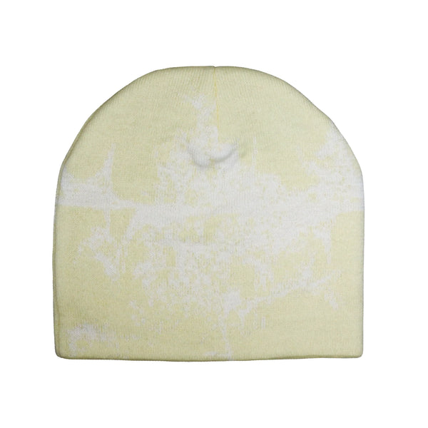 “A pale yellow knit beanie featuring a subtle white abstract graphic design resembling a textured, organic pattern across the surface. The beanie has a simple, rounded shape with no visible logos or additional details.”