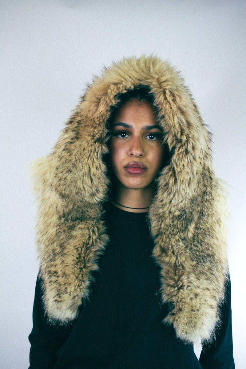 Model wearing detachable fur hood scarf with long fur panels, front view.