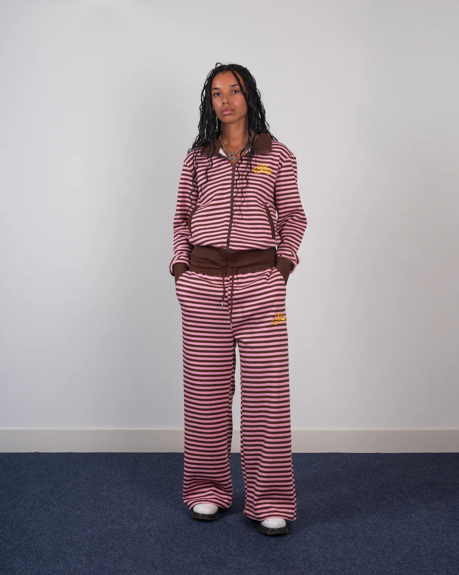 Person wearing a red and white striped outfit with a brown belt against a plain background