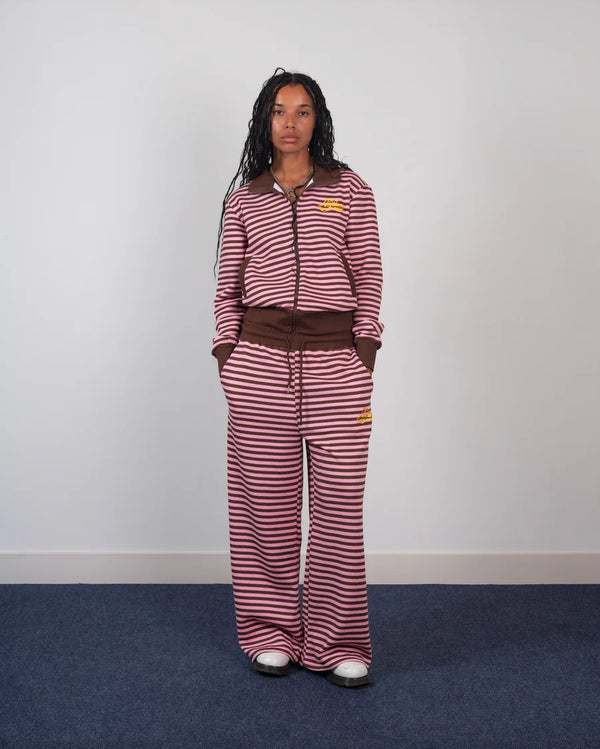 Person wearing a red and white striped outfit with a brown belt against a plain background