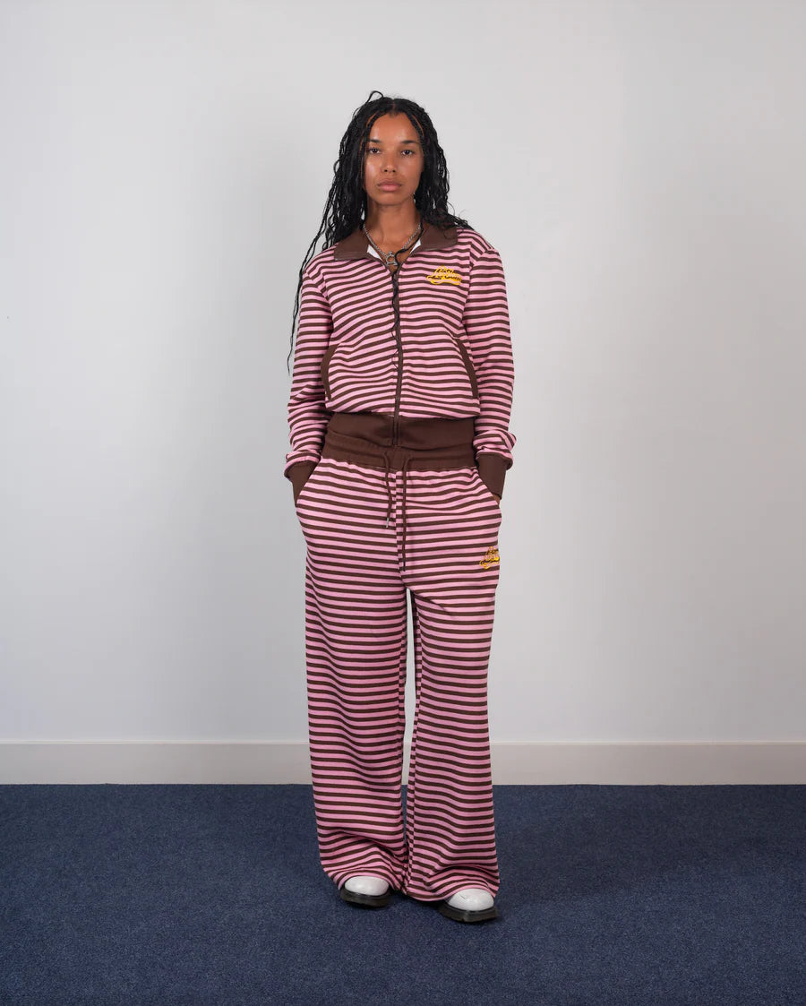 Person wearing a red and white striped outfit with a brown belt against a plain background