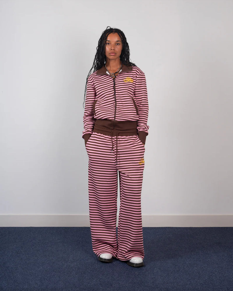 Person wearing a red and white striped outfit with a brown belt against a plain background