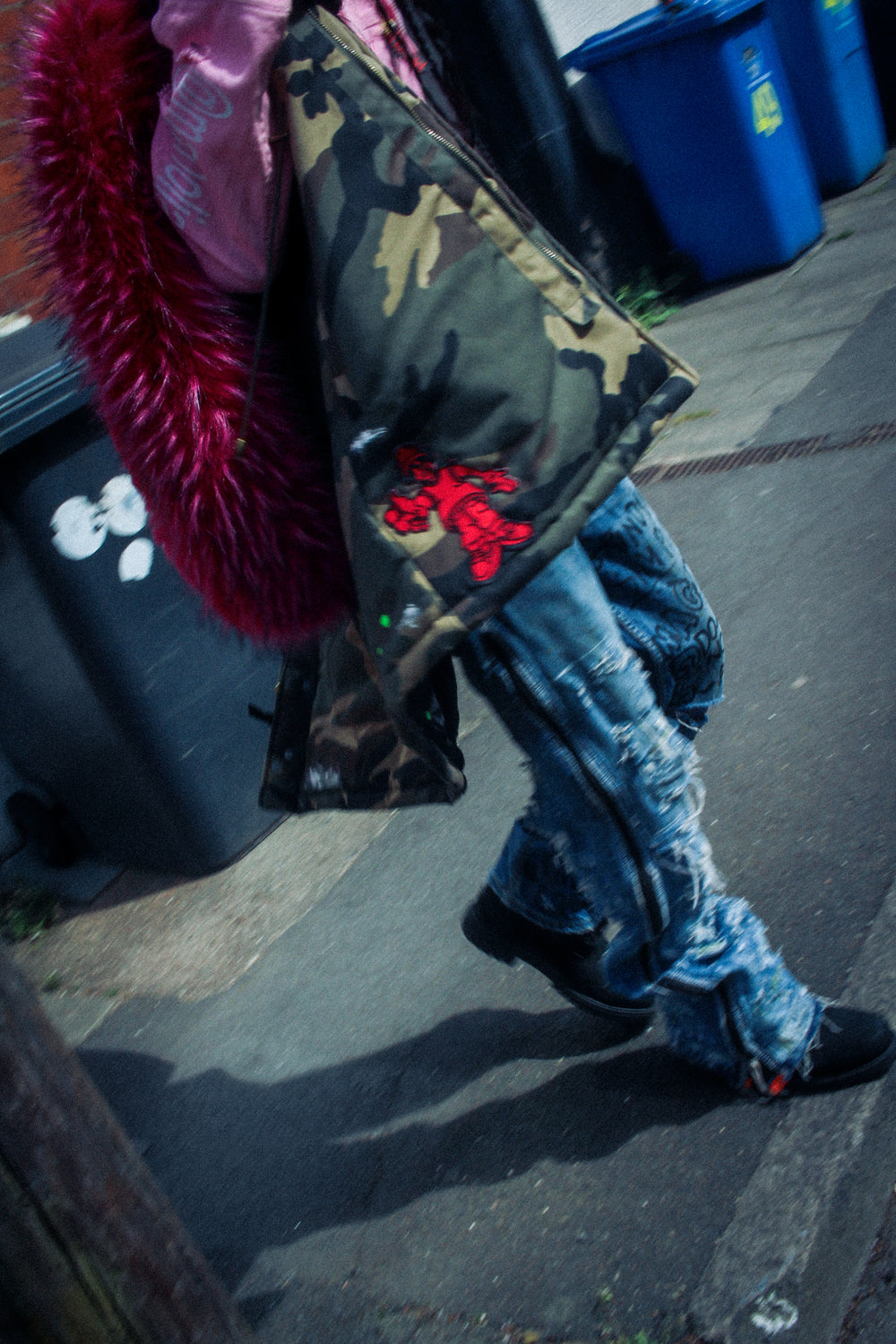 Close-up detail of camouflage padded vest showing fabric texture, snap buttons, and graphic print.