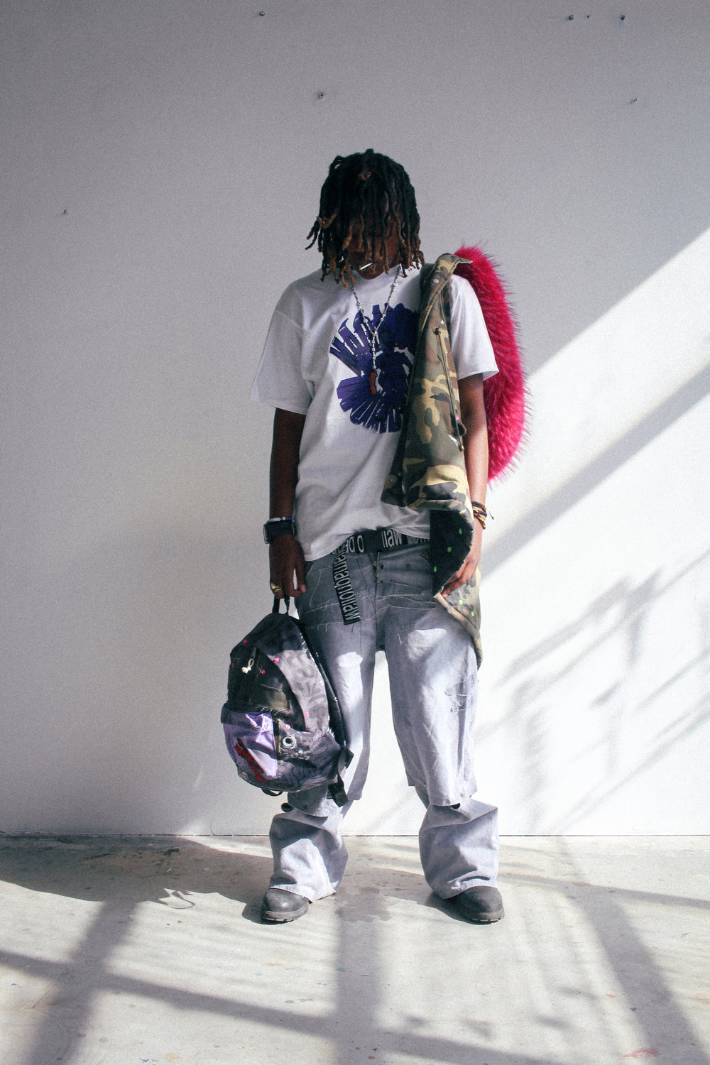 Camouflage hooded padded vest worn over white graphic T-shirt, featuring oversized pink faux fur hood trim and printed details.