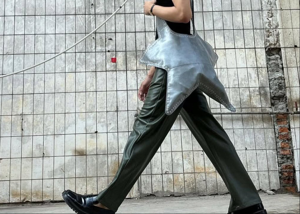 person who is wearing Green faux leather pants walking against the wall