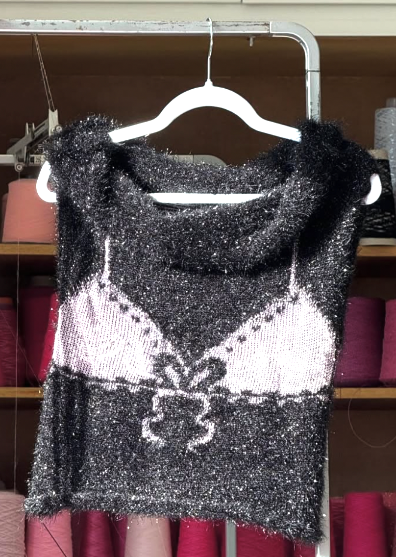 Black and pink knitted top with bra design on a hanger