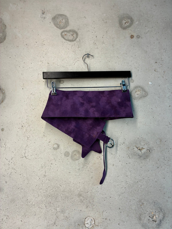 Purple fabric on a hanger against a textured gray background