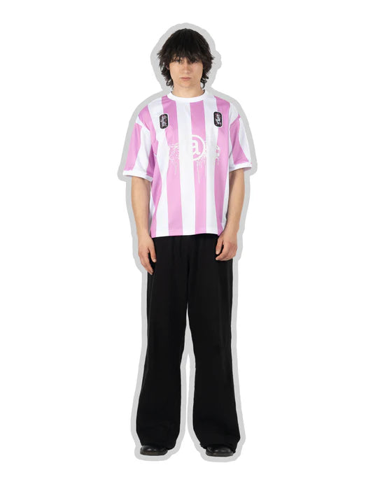 Person wearing a pink and white striped shirt with black pants on a white background