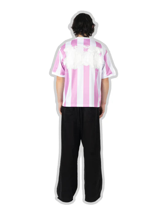 Person wearing a pink and white striped shirt with black pants on a white background