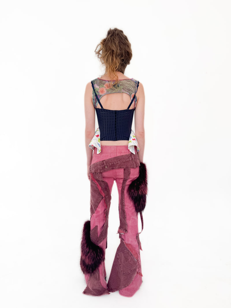 Person wearing a unique outfit with a black top and pink pants on a white background