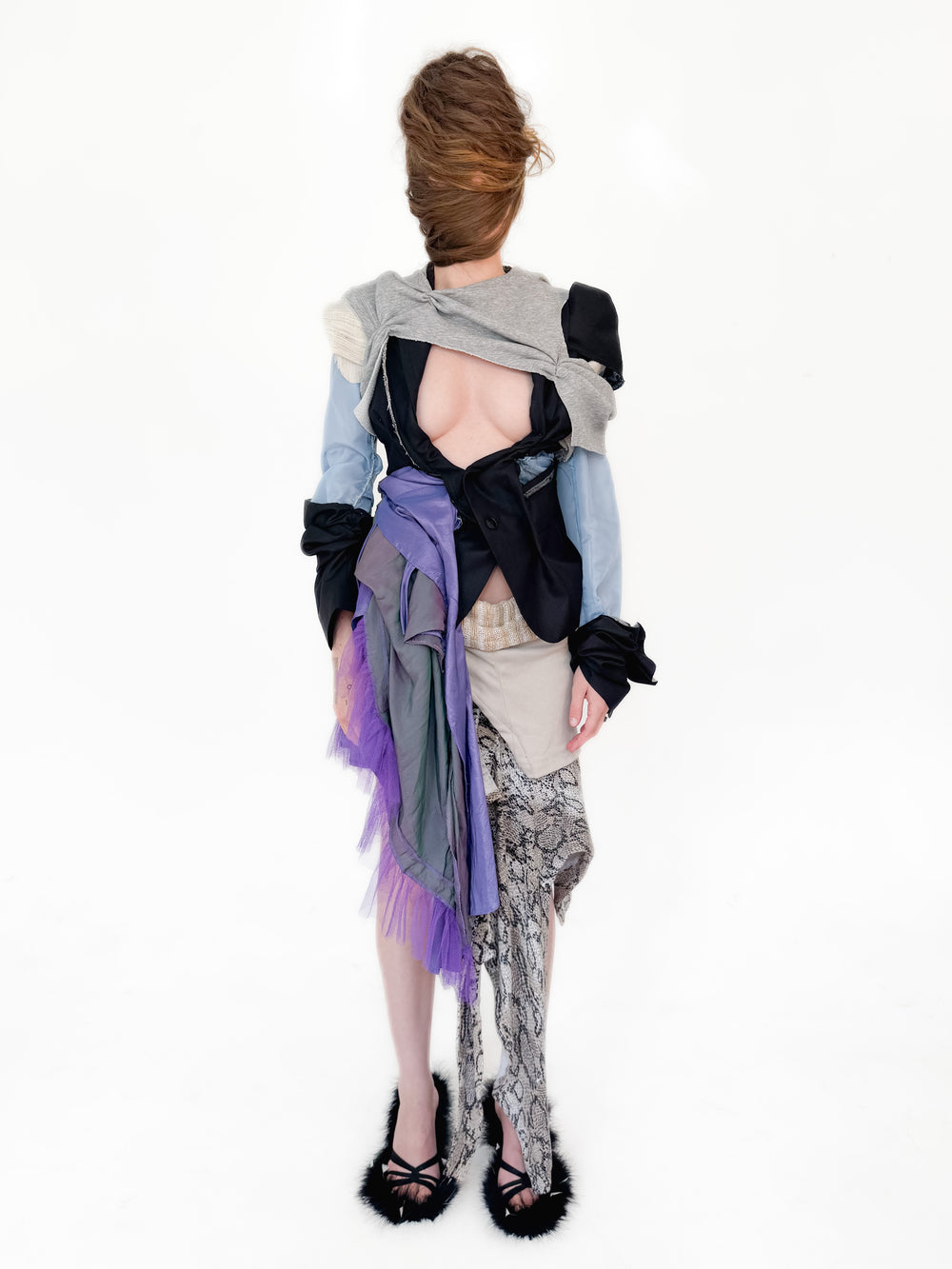 Person wearing a colorful, layered outfit with a white background