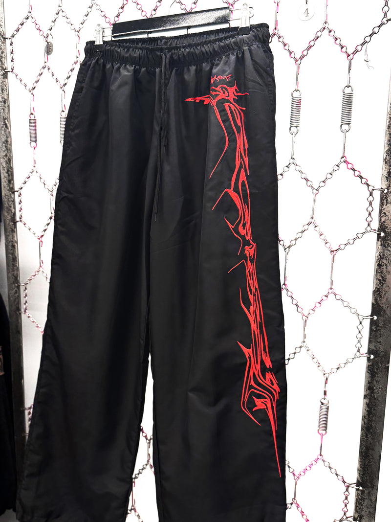 Black pants with red tribal design on a white background