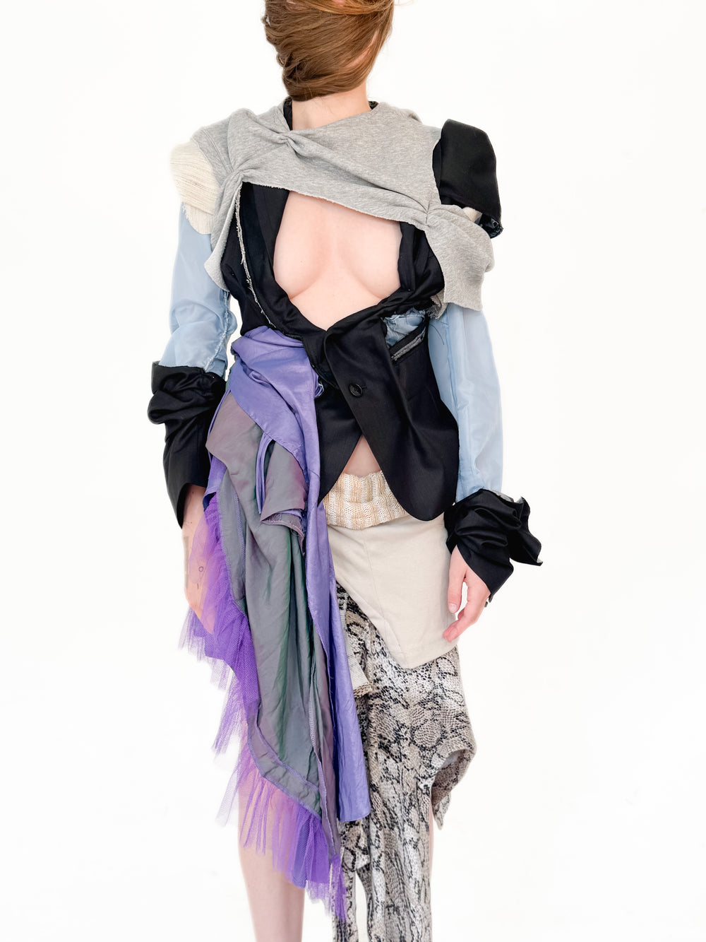 Person wearing a colorful, layered outfit with a white background