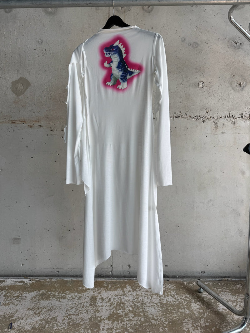 White asymmetrical long-sleeve dress featuring a vibrant blue dinosaur graphic with pink airbrush-style outline on the back – YAKU’s Afrofuturist streetwear from “Impossible Family Reunion in RPG Space” collection