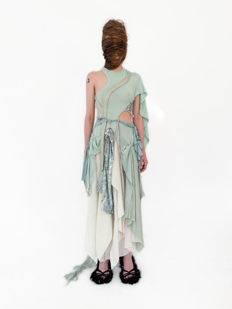 Woman wearing a light green dress with cut-out design on a white background