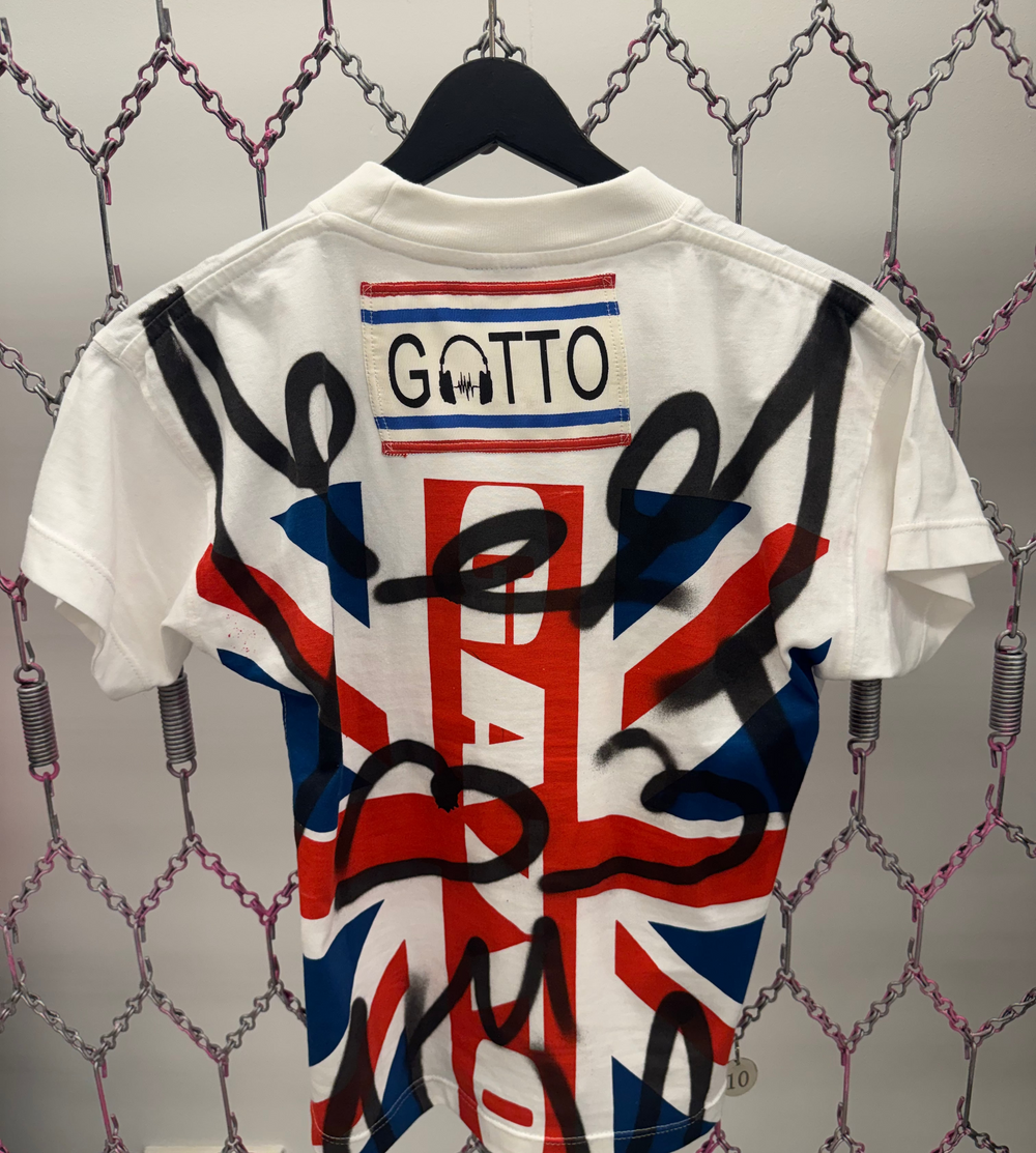 White shirt with British flag design and 'Gatto' branding on a textured wall background