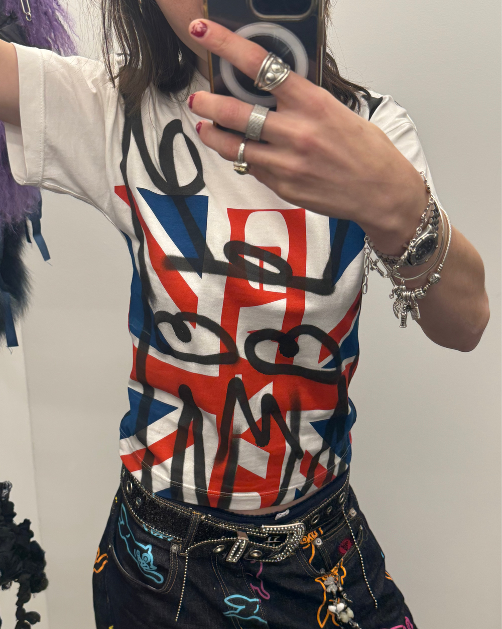 Person wearing a graphic t-shirt with a Union Jack design and colorful pants.