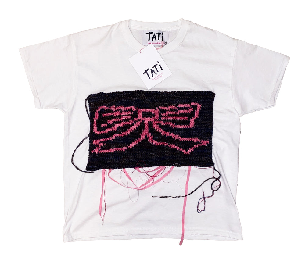 White t-shirt with black and pink design, featuring the brand 'Tati'.