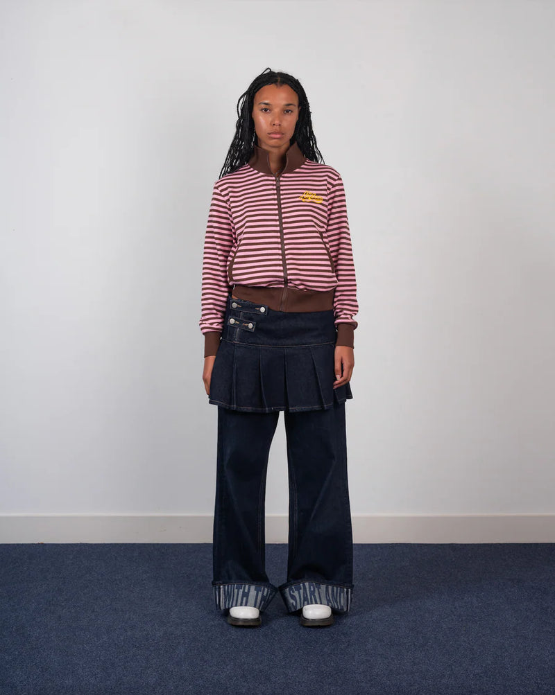 Person wearing a striped sweater and pleated skirt on a plain background