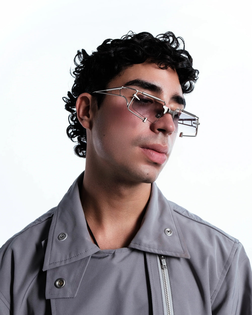 Man wearing glasses and a gray jacket on a white background