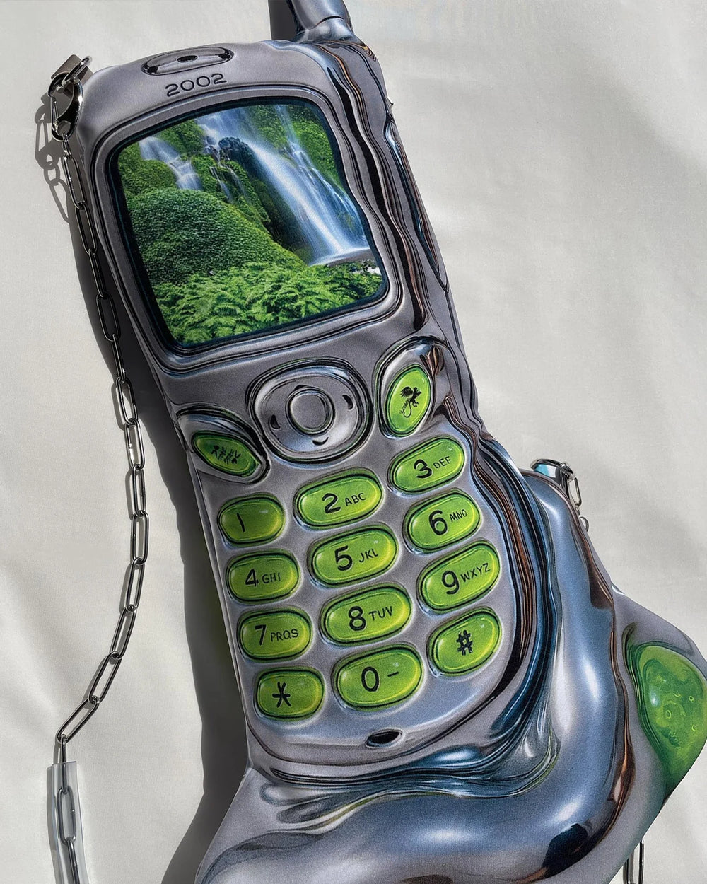 Vintage silver and green flip phone with a waterfall on the screen