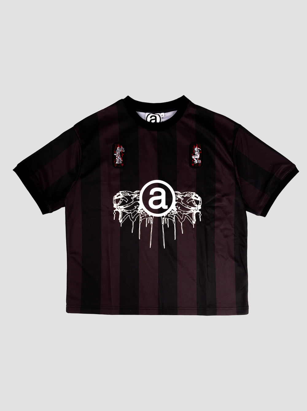 Black and dark red striped T-shirt with a large '@' symbol graphic in the center, surrounded by white abstract designs. Two small embroidered patches add detail on the upper chest. The shirt has a bold, modern aesthetic, merging streetwear style with graphic elements for a distinctive look.