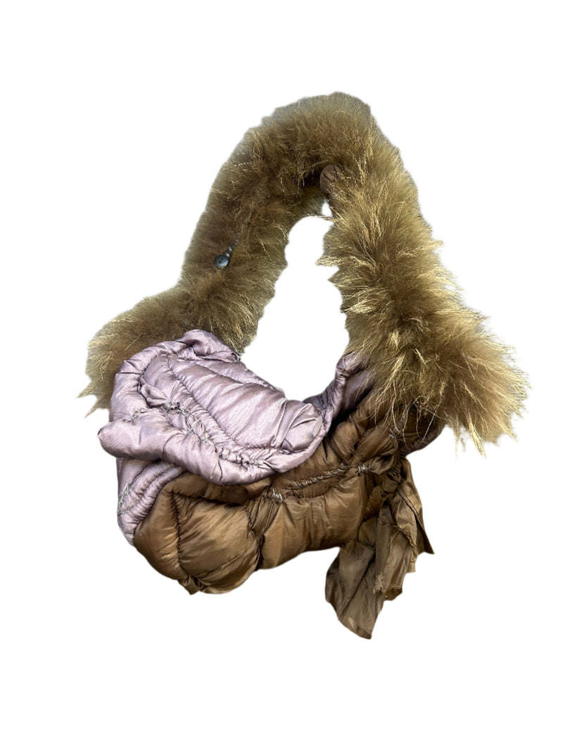 Pink quilted handbag with fur trim on a wooden floor
