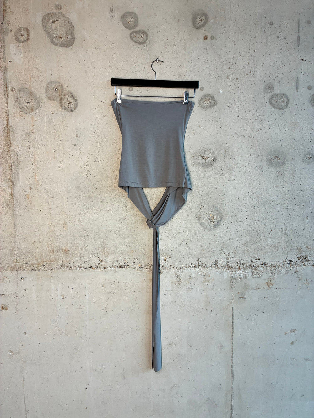 Drop down tube top is hanging on the wall with the product detail shot. 