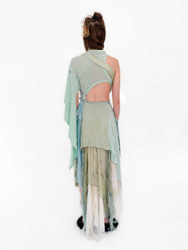 Woman wearing a light green dress with cut-out design on a white background